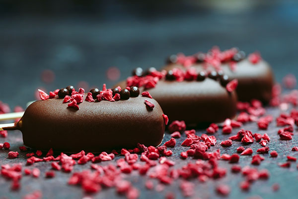 चॉकलेट बार फ्रीझ-वाळलेल्या रास्पबेरीसह शिंपडले जातात